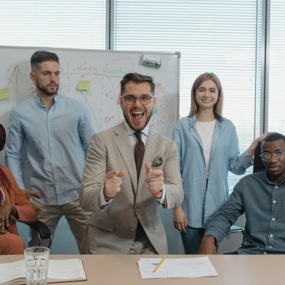 A diverse group of professionals in a lively office meeting, showcasing teamwork and collaboration.